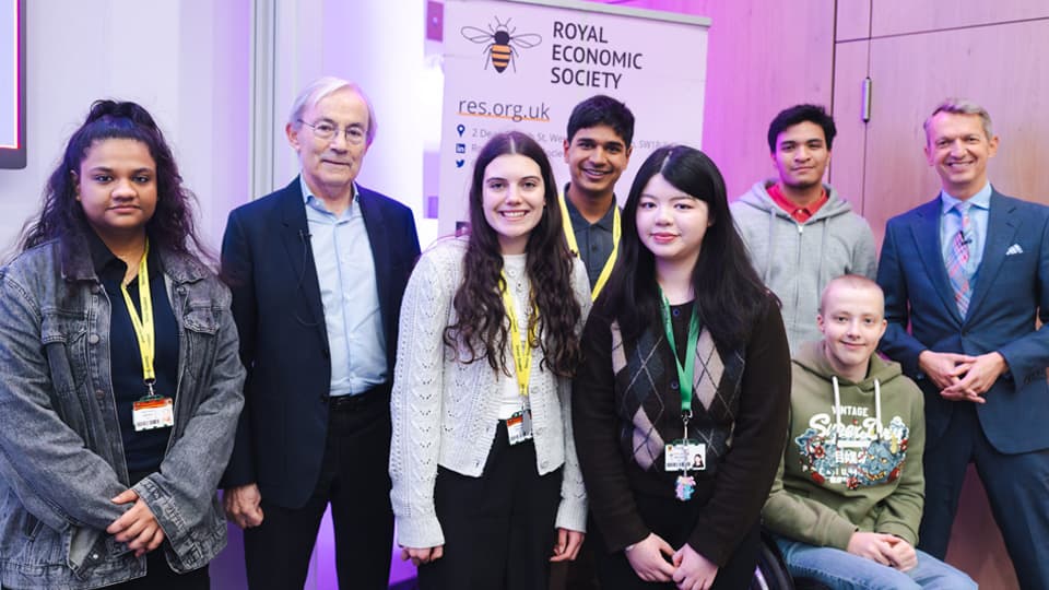 Royal Economic Society Annual Lecture speakers Sir Chris Pissarides and Andrew Haldane CBE pose for a photo with a group of sixth-form student attendees.